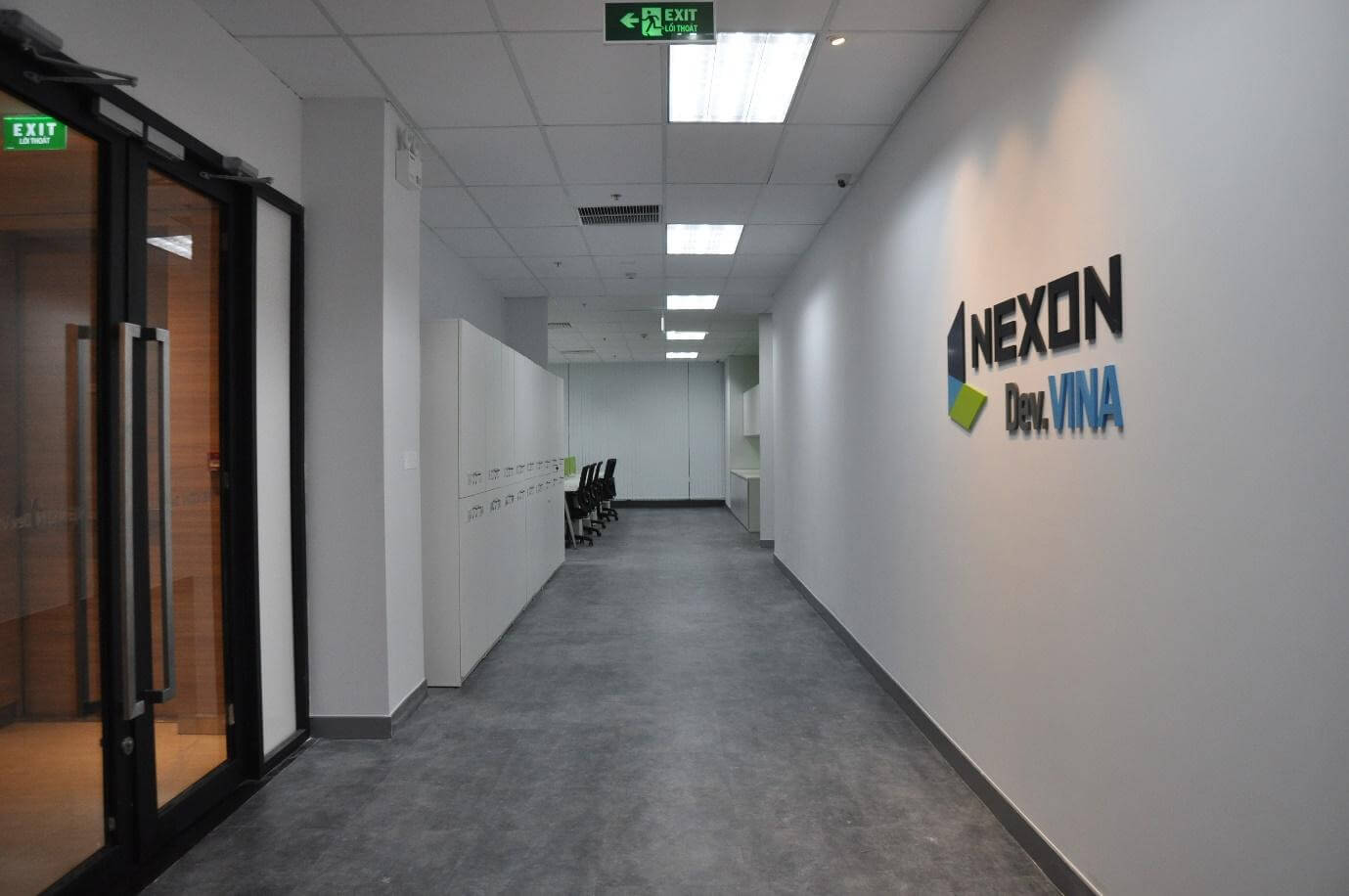 Lối vào công ty là bức tường lớn, nền trắng làm nổi bật logo của doanh nghiệp